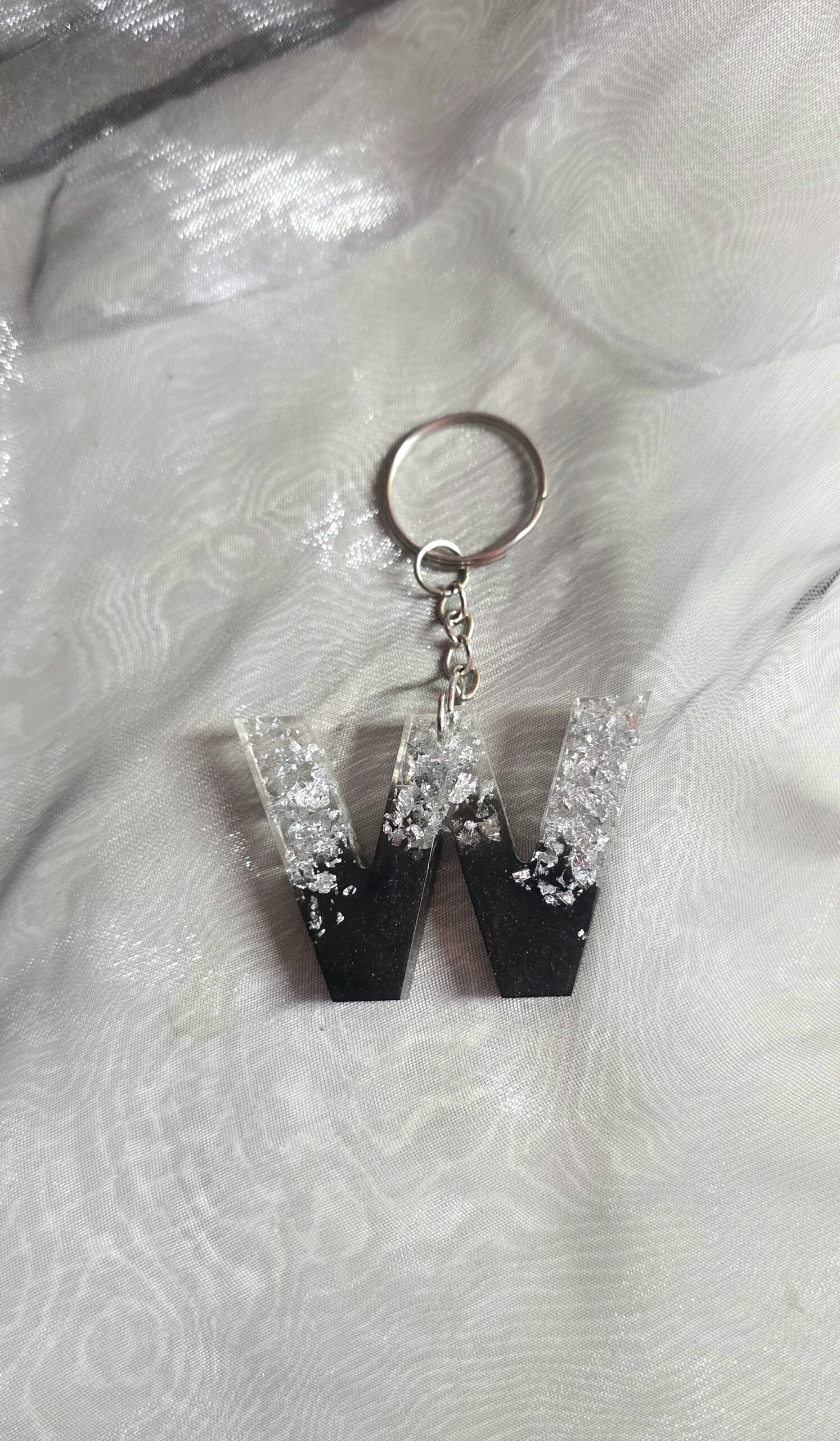 Handgefertigter Schlüsselanhänger Buchstabe W aus Epoxidharz – Edles Design in Schwarz mit funkelnden silbernen Glitzer-Details als Unikat von Traumharz.