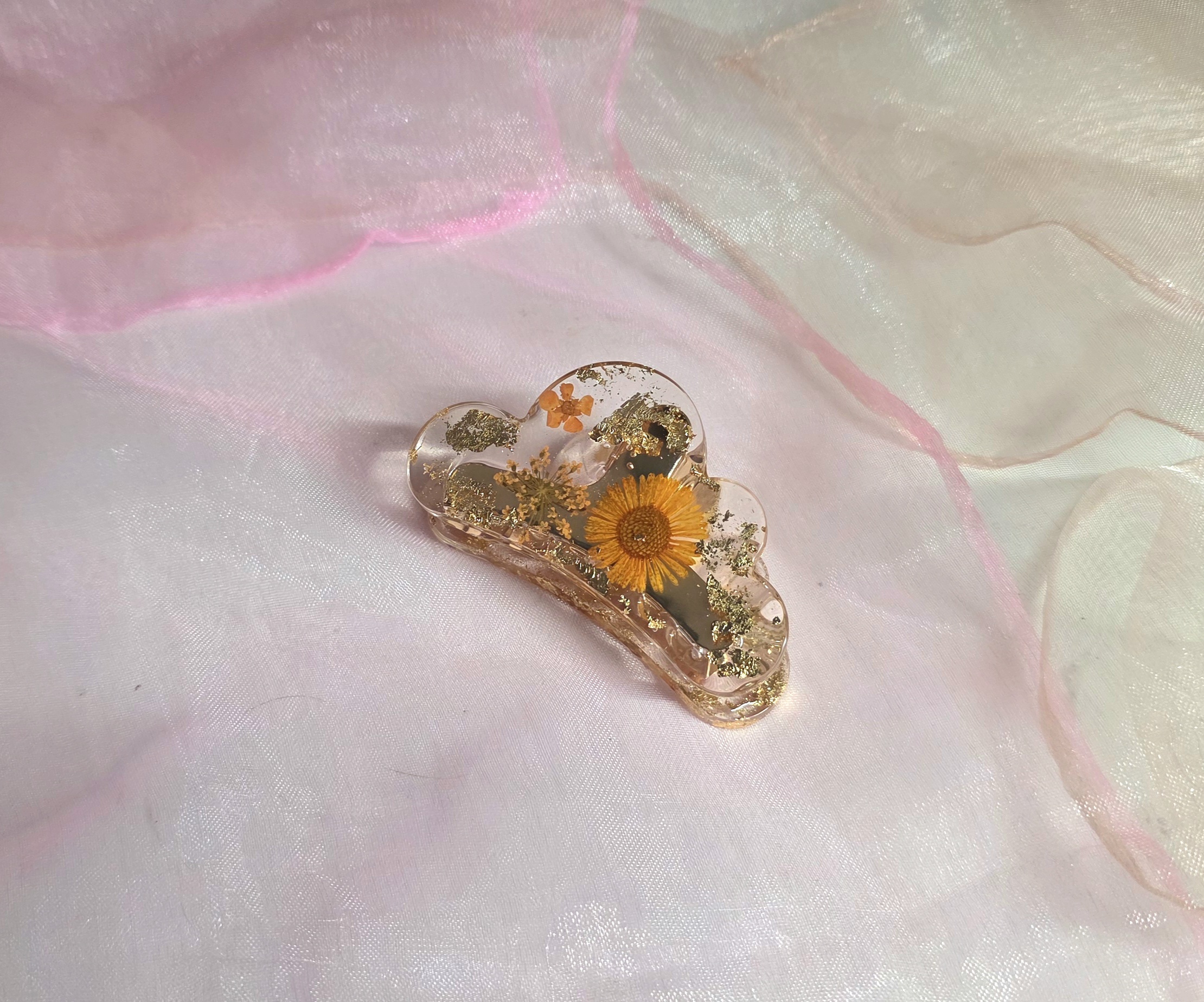 Handgegossene Haarklammer mit orangefarbenen Blumen und Blattgold-Details von Traumharz.