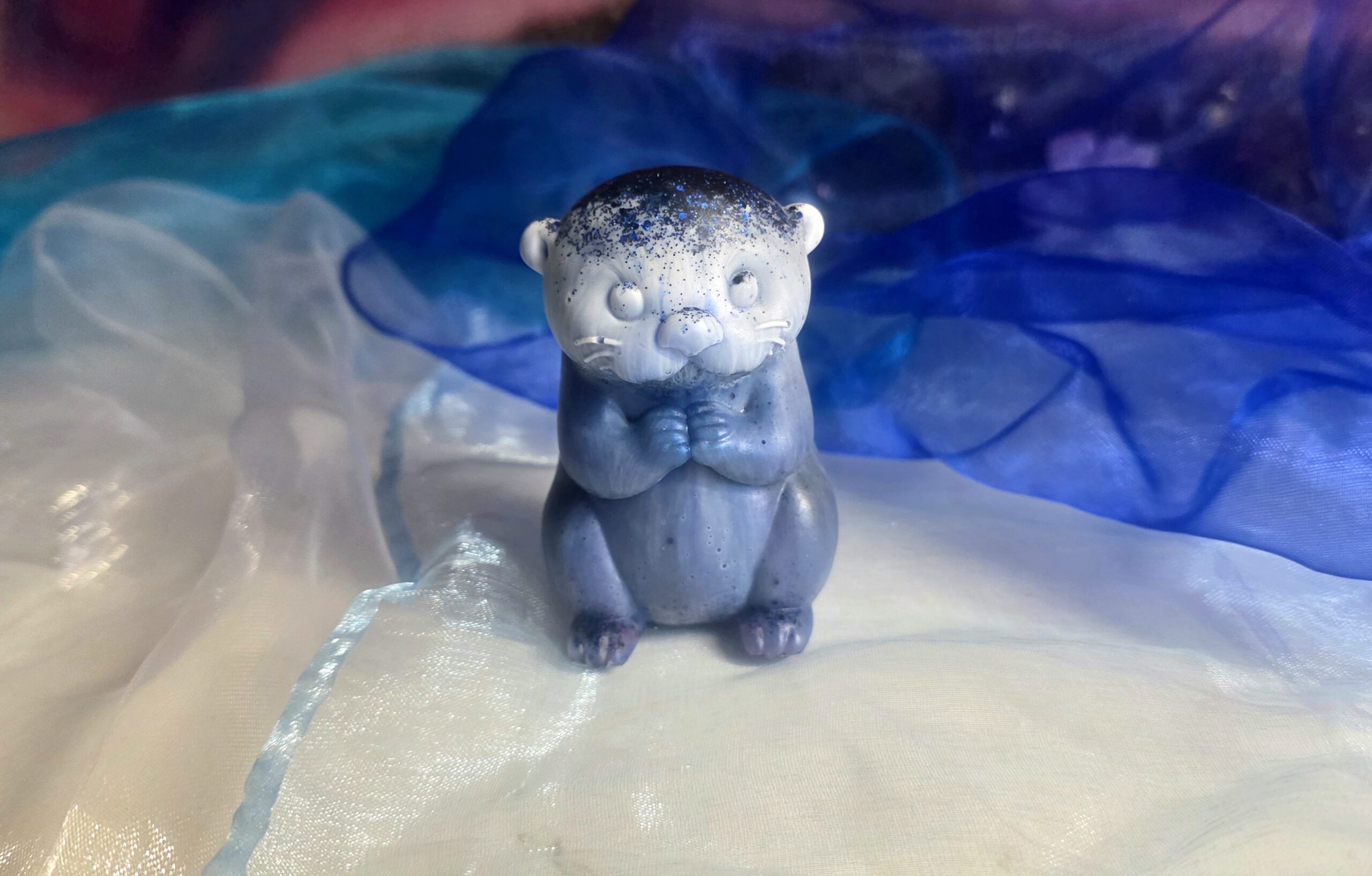 Handgefertigte Otter-Figur „Nachtpfote“ aus Epoxidharz in Nachtblau mit Sternen-Glitzer und schützenden Gumminoppen auf der Unterseite – Einzigartiges Resin-Sammlerstück von Traumharz.