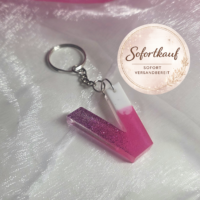 Handgefertigter Buchstaben-Schlüsselanhänger (Buchstabe V) aus Epoxidharz im edlen Farbverlauf Pink-Weiß mit glänzendem Finish und silbernem Ring.